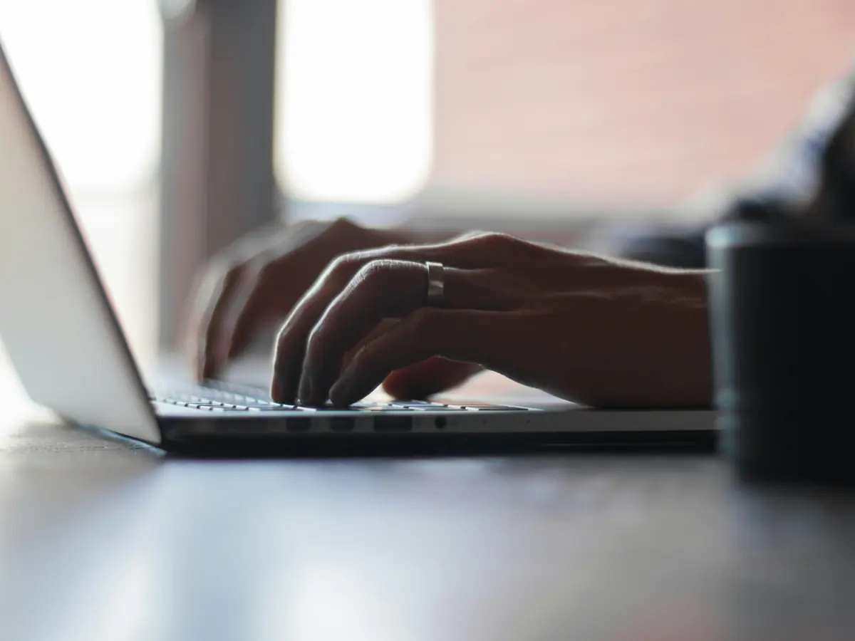 Mains sur le clavier d'un ordinateur portable