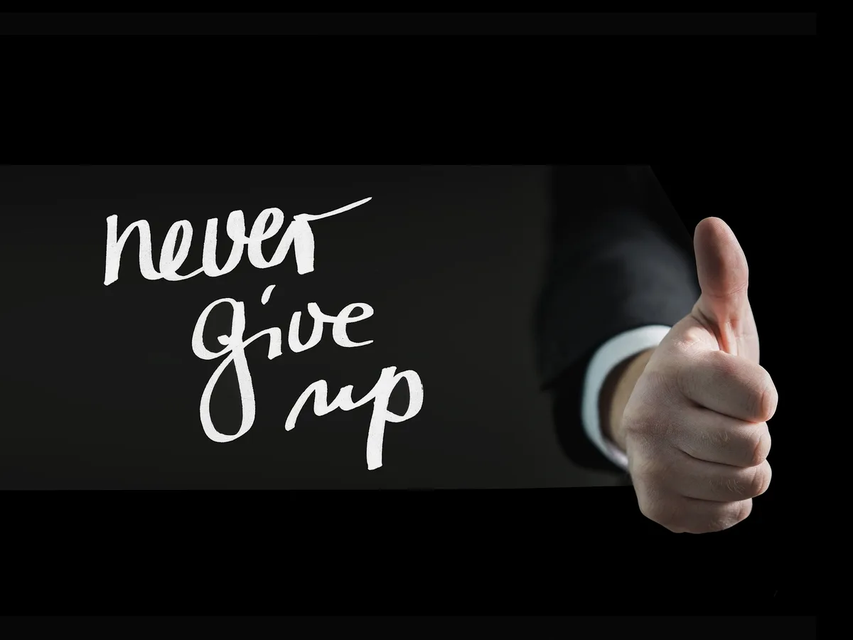 Pouce levé devant l'inscription never give up