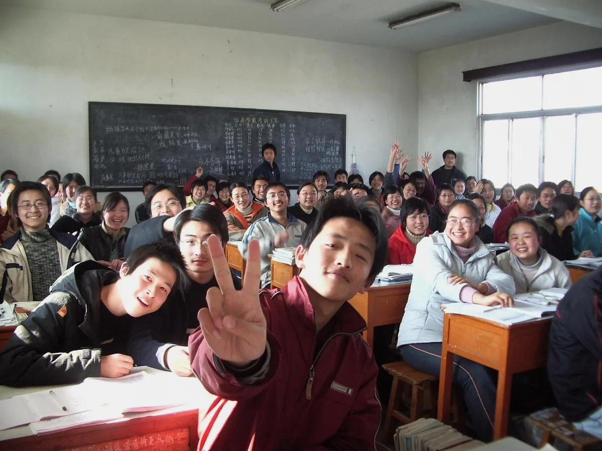 Photo de classe, élèves souriants dans une salle de cours
